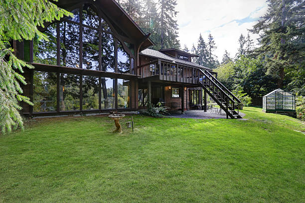 istock Modern countryside wooden house with big mirrored windows. 617360108