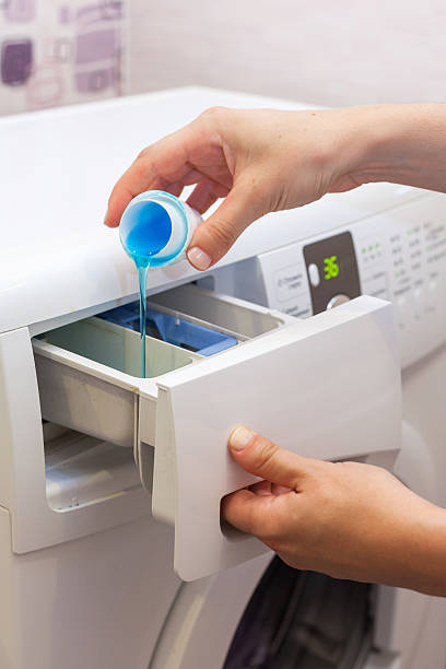 istock She pours the liquid powder in washing machine 617360598