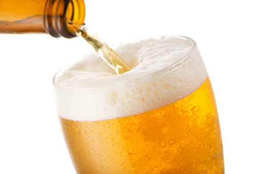 Beer pouring into glass isolated on a white background
