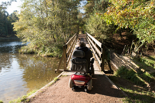 Senior woman on electric scooter in the Forest of Dean, UK
