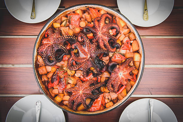 preparing and cooking of octopus in traditional croatian peka sa - dinner croatia bildbanksfoton och bilder