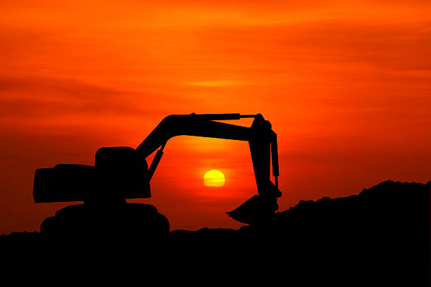 istock silhouette of excavator machine with sunset 617367084