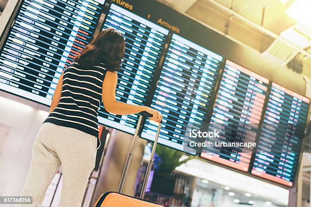 Asiatische Frau Reisende Blick Auf Fluginformationen Bildschirm In Flughafen Stockfoto und mehr Bilder von Flughafen