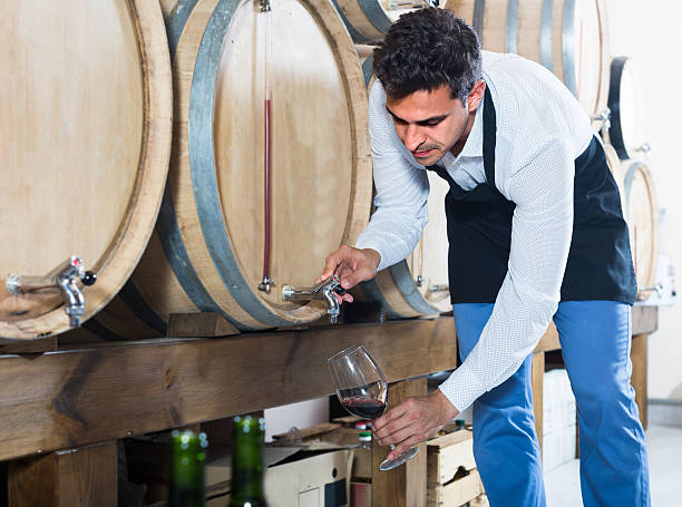 seller taking wine from wood