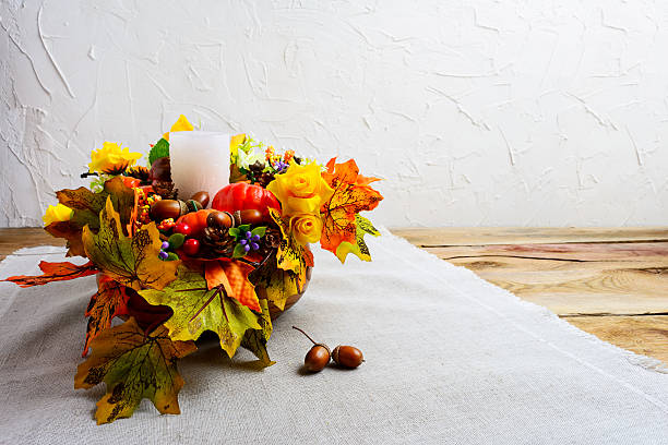 istock Thanksgiving centerpiece with decorated candle and silk fall lea 617370858