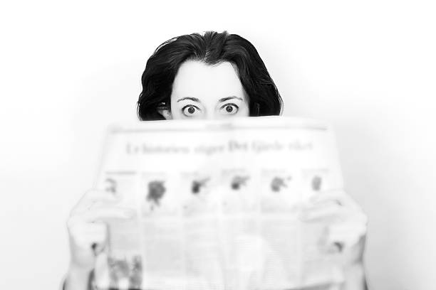 istock Woman with newspaper in shock 617370972