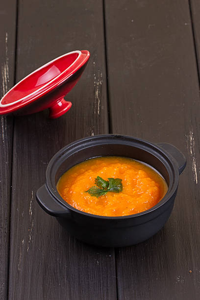 istock pumpkin soup in a small black pot 617371488