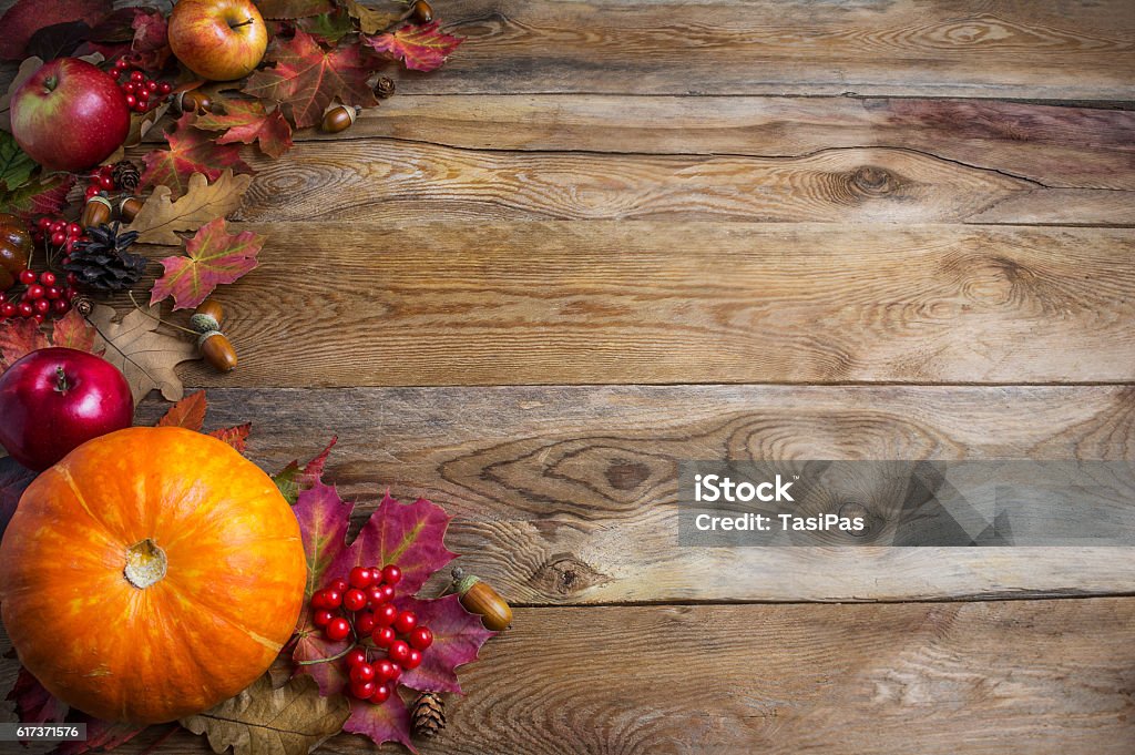 Thanksgiving  or fall greeting background with orange pumpkins a Thanksgiving  or fall greeting background with orange pumpkins and fall leaves. Thanksgiving background with seasonal vegetables and fruits. Fall background. Copy space Cornucopia Stock Photo