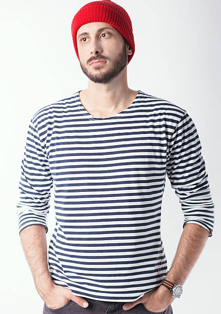 Young bearded man in sailor shirt and wool cap in Jacques Cousteau's style.