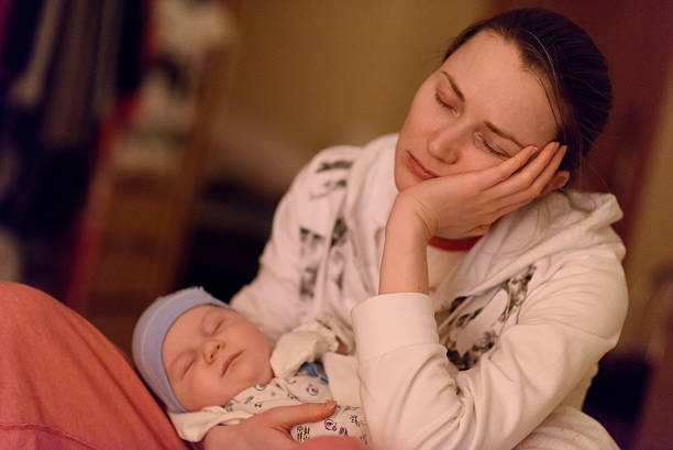 istock tired mother holds sleeping baby on hands 617374458