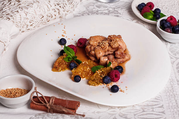 Chicken teriyaki sauce with raspberry and blueberry, quenelle of orange stock photo