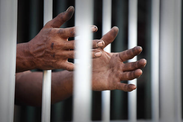 istock hand of prisoner in jail 617376538