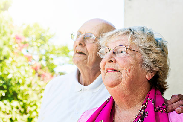 vecchia coppia sposata in giardino guardare in alto, felicemente stupito - aging process affectionate vitality awe foto e immagini stock