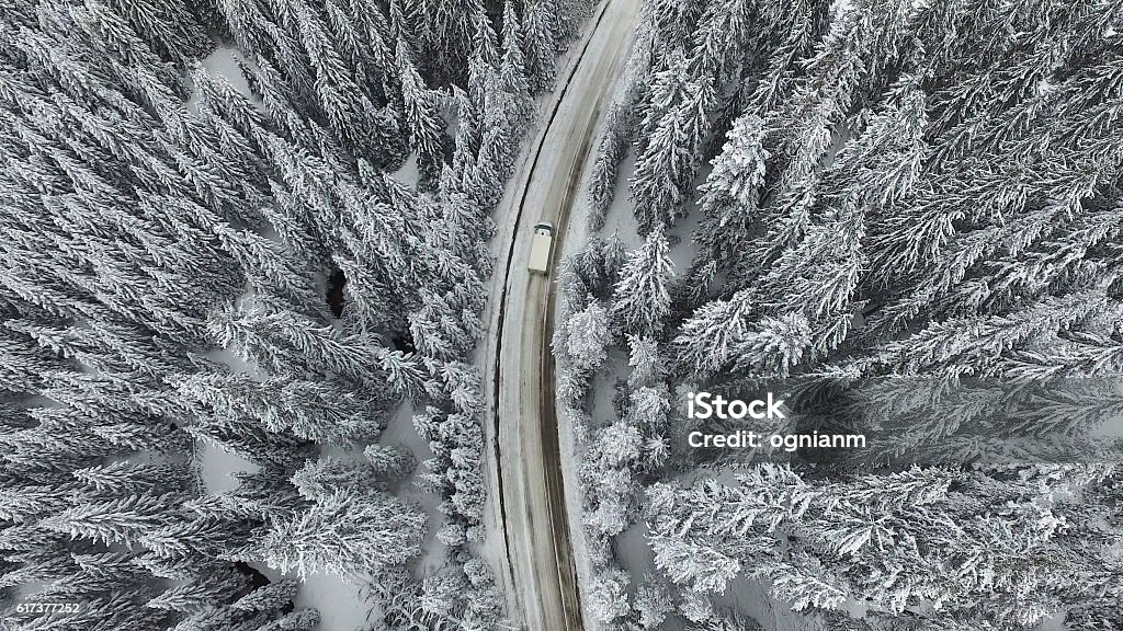 Snowy Winter Road with a Car Snowy and frozen winter road with a moving car on it. Snow Stock Photo