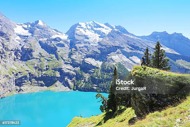 Hiker Admiring Oeschinen Lake From Heuberg Lookout In Switzerland Stock Photo - Download Image Now