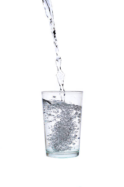 istock Fresh water pouring in a glass on white background 617379394