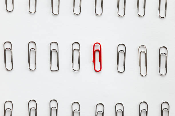 istock Metal paperclips in rows, one red different from the others 617379966