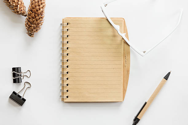 istock White office desk with glasses, pen, notebook and cone on 617380234