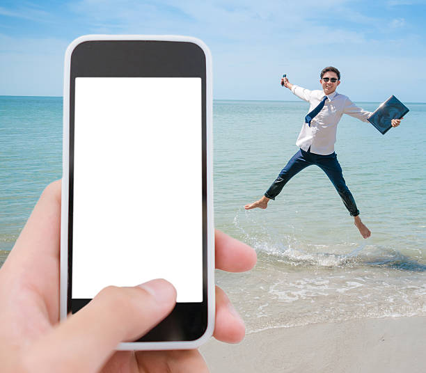 Business man working with laptop and smartphone beach background