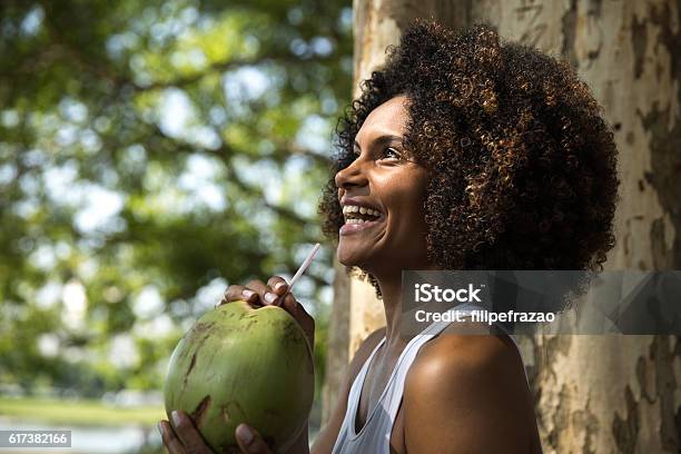 Brazilian Woman Drinking Coconut Water In The Park Stock Photo - Download Image Now - Coconut, Coconut Palm Tree, Happiness