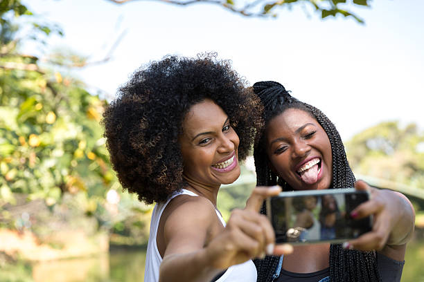 mulheres afro tirando fotos de selfie no parque - indigenous culture nigerian culture african descent nigeria - fotografias e filmes do acervo