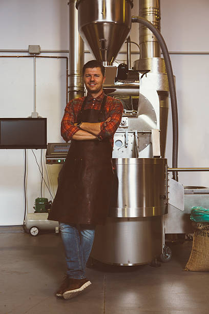 istock Coffee roaster with arms crossed at iron machine 617382640