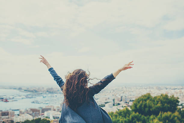istock cheerful young woman with hands up. 617383398
