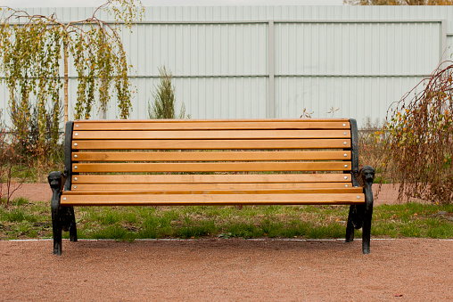 wooden bench in front of a fence