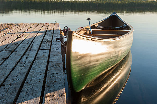 istock Wooden dock with canoe at sunset 617384786