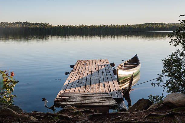 istock Rustic dock with canoe at sunset on a lake 617385774
