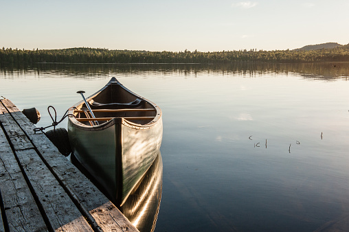 Rustic dock with canoe at sunset on Haymock lake in Northern Maine