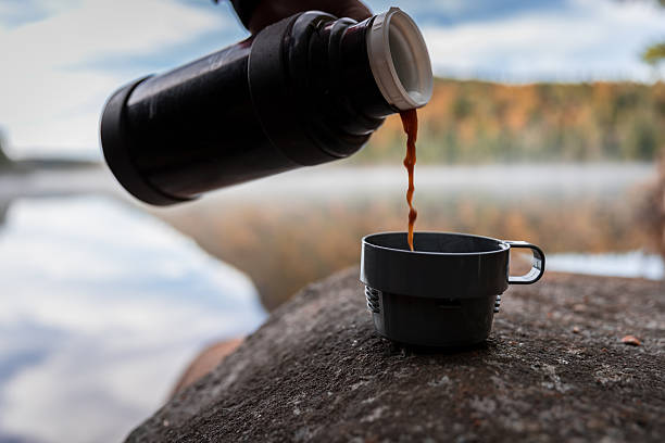 istock Human Hand Pouring a Coffee Cup in Nature 617386740