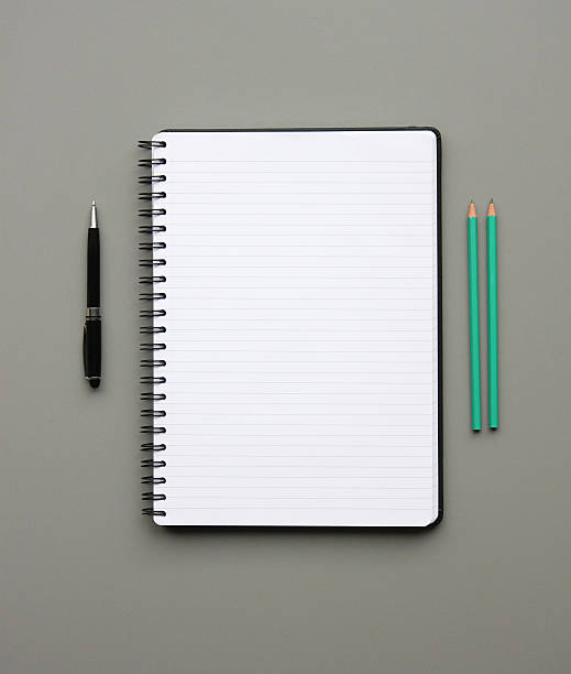 Notepad A notepad, pen and pencils neatly aligned on a desk. green ruled note paper stock pictures, royalty-free photos & images