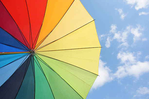 istock Multicolored umbrella against the sunny sky 617388450