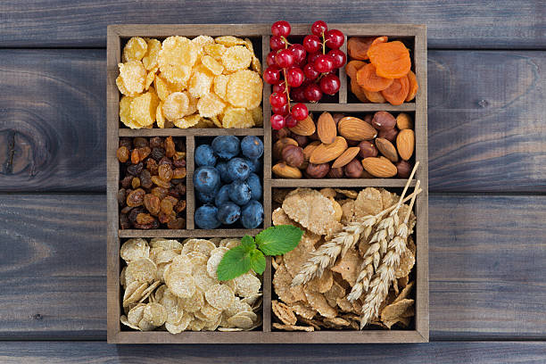 istock breakfast cereal, dried fruit, berries and nuts in wooden box 617389460