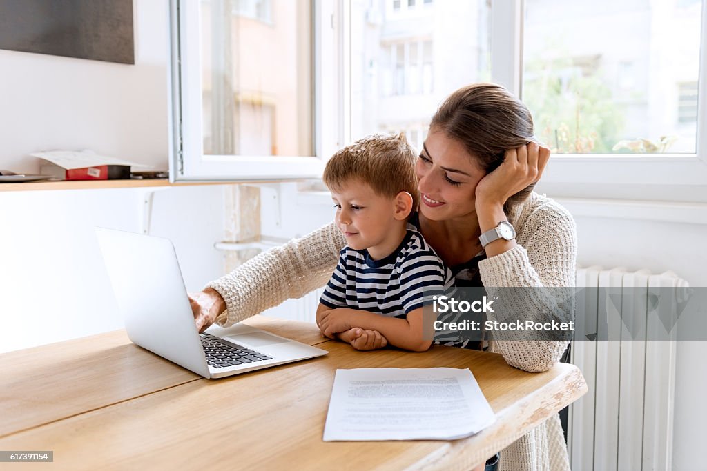 Working with mommy Young mother working from home Mother Stock Photo