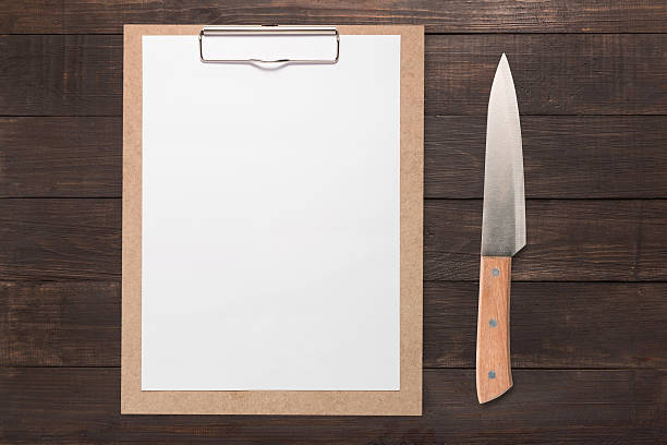 istock Clip board and knife set on wooden background. 617391162