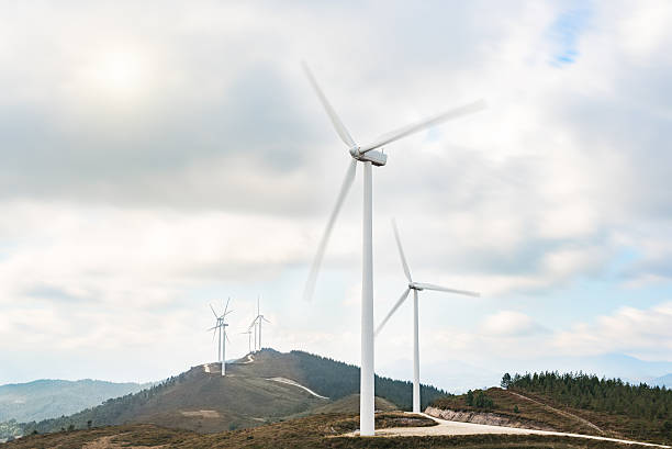 Wind turbines farm in eolic park generating energy with air Wind turbines farm in eolic park generating energy with air flow with spinning blades in a rural setting. Clean renewable green wind power concept. fuel and power generation greenhouse efficiency power supply stock pictures, royalty-free photos & images