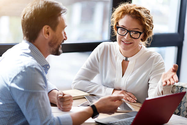 istock Middle-aged man and woman discussing information from laptop 617391684