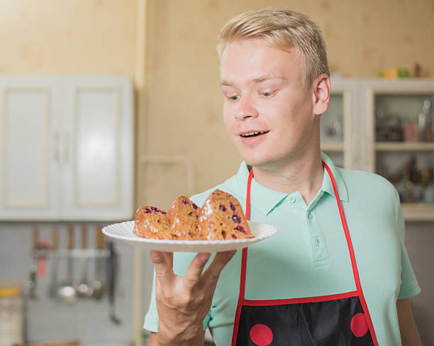 handsome man holding a cake, enjoying closed his eyes.