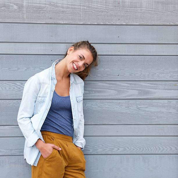 istock Smiling confident woman leaning against wall 617397620