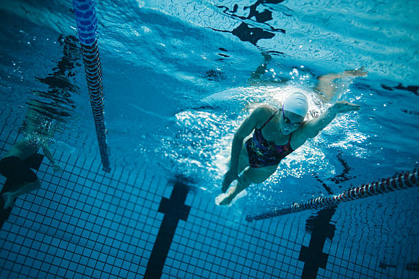 istock Young female swimmer training in the pool 617399542