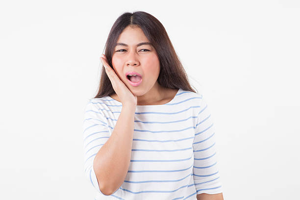 istock suffering from toothache. frustrated young woman touching her cheek 617567922