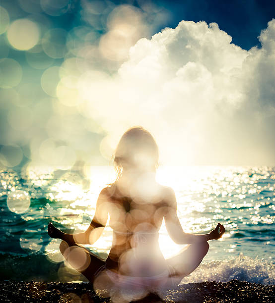 Woman Practicing Yoga by the Sea. Bokeh Background Woman Practicing Yoga by the Sea. Silhouette of a Slim Girl. Nature Background with Sunlight Bokeh. Meditation, Spiritual and Soul Concept. Healthy Lifestyle. Double Exposure Filtered Photo. sun exposure stock pictures, royalty-free photos & images