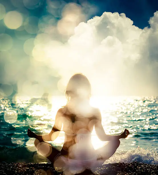 Photo of Woman Practicing Yoga by the Sea. Bokeh Background