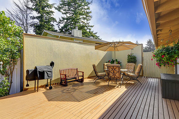 istock Patio table set with opened umbrella. Wooden walkout deck 617570068