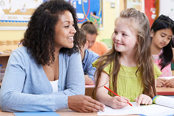 istock Teacher With Female Elementary School Pupil In Class 617570938