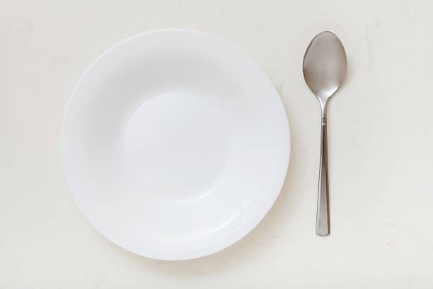 istock top view of white deep plate and spoon on plaster 617574034