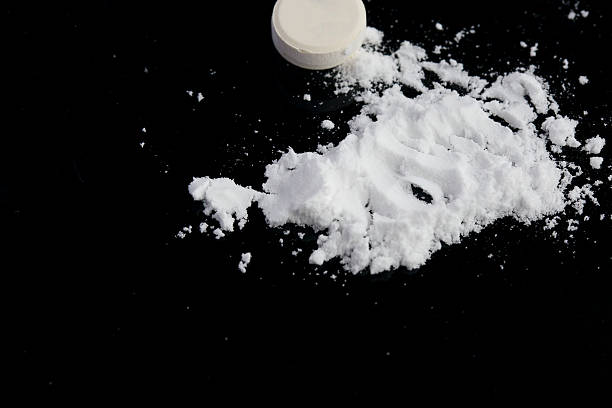 istock Narcotic drugs on a black surface. Closeup 617574828