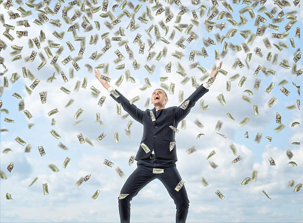 happy businessman in celebrating pose with loads of money in - çok sayıda nesne stok fotoğraflar ve resimler